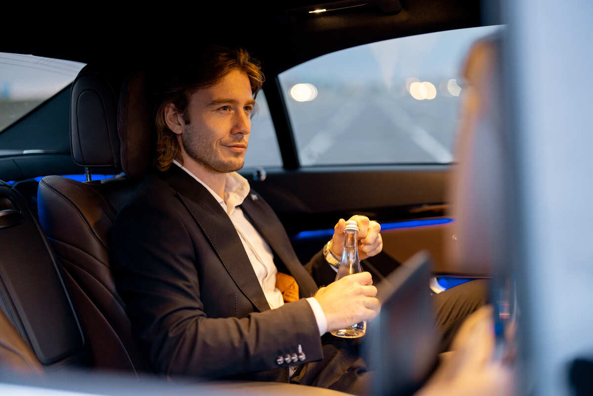 Businessman on backseat of luxury car